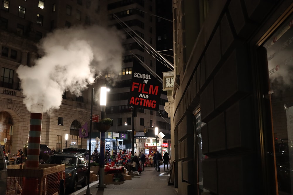 a city street at night with a lot of smoke coming out of it