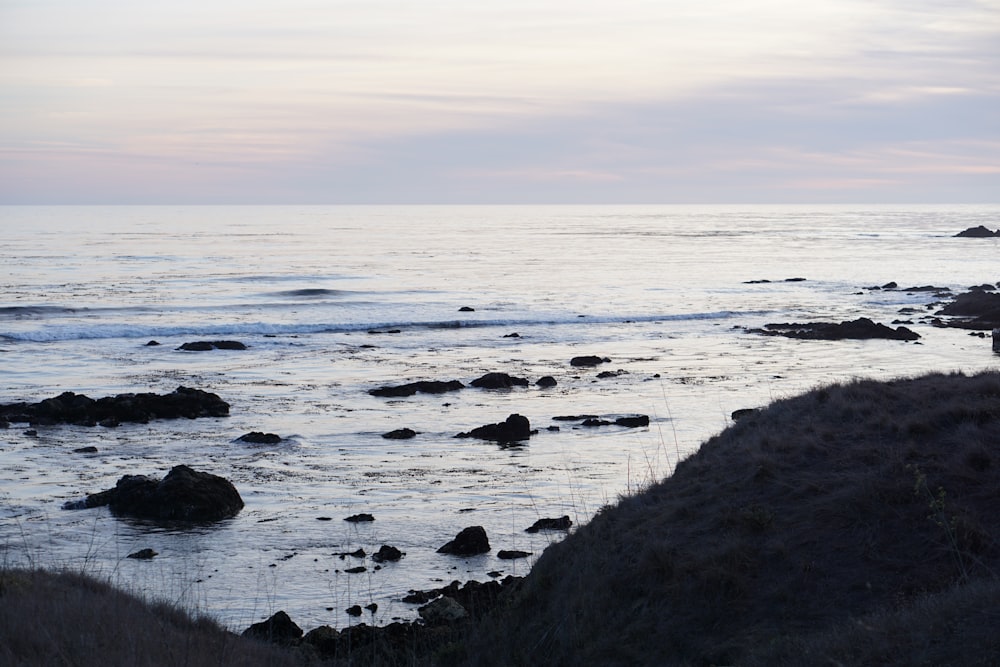 a view of a body of water with rocks in the foreground