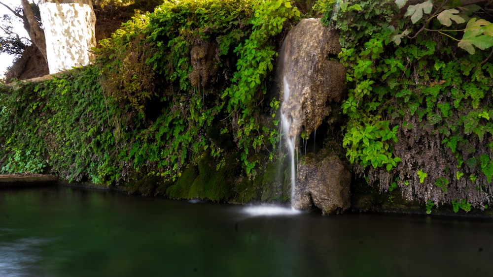 a small waterfall in the middle of a pool of water