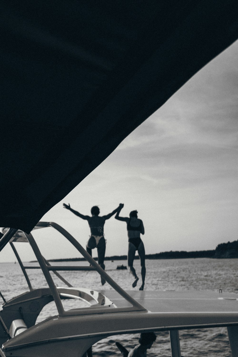 two people jumping off a boat into the water