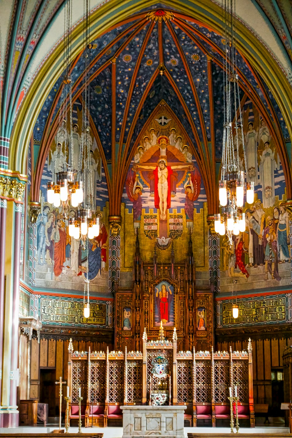 a church with a large alter and chandeliers