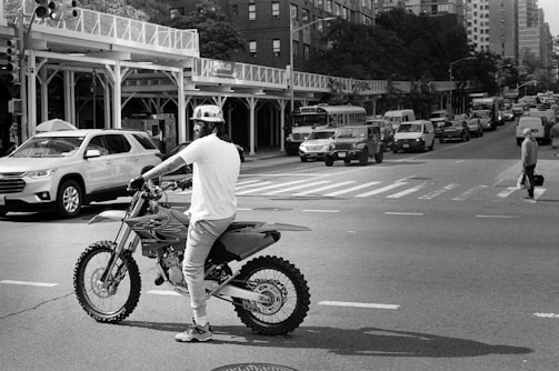 a man riding a dirt bike across a street