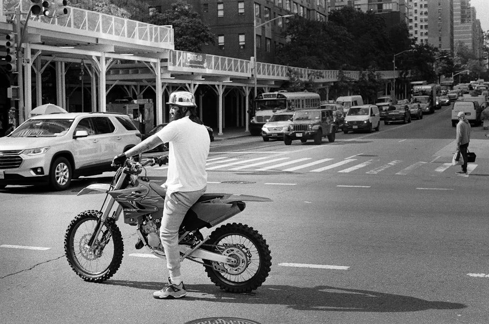 a man riding a dirt bike across a street