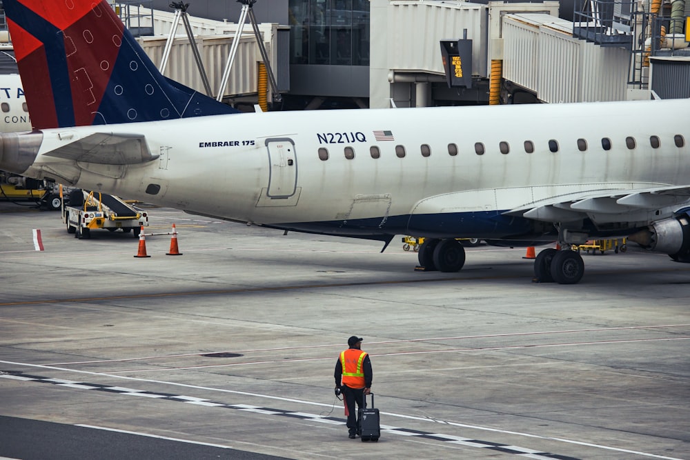 a man standing in front of an airplane at an airport