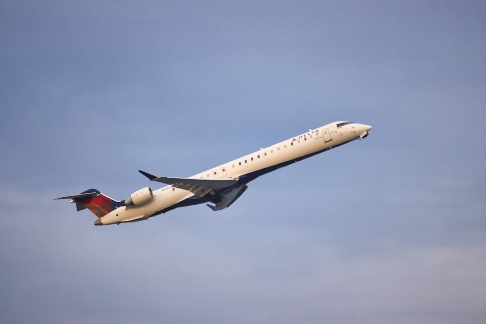 a large jetliner flying through a blue sky