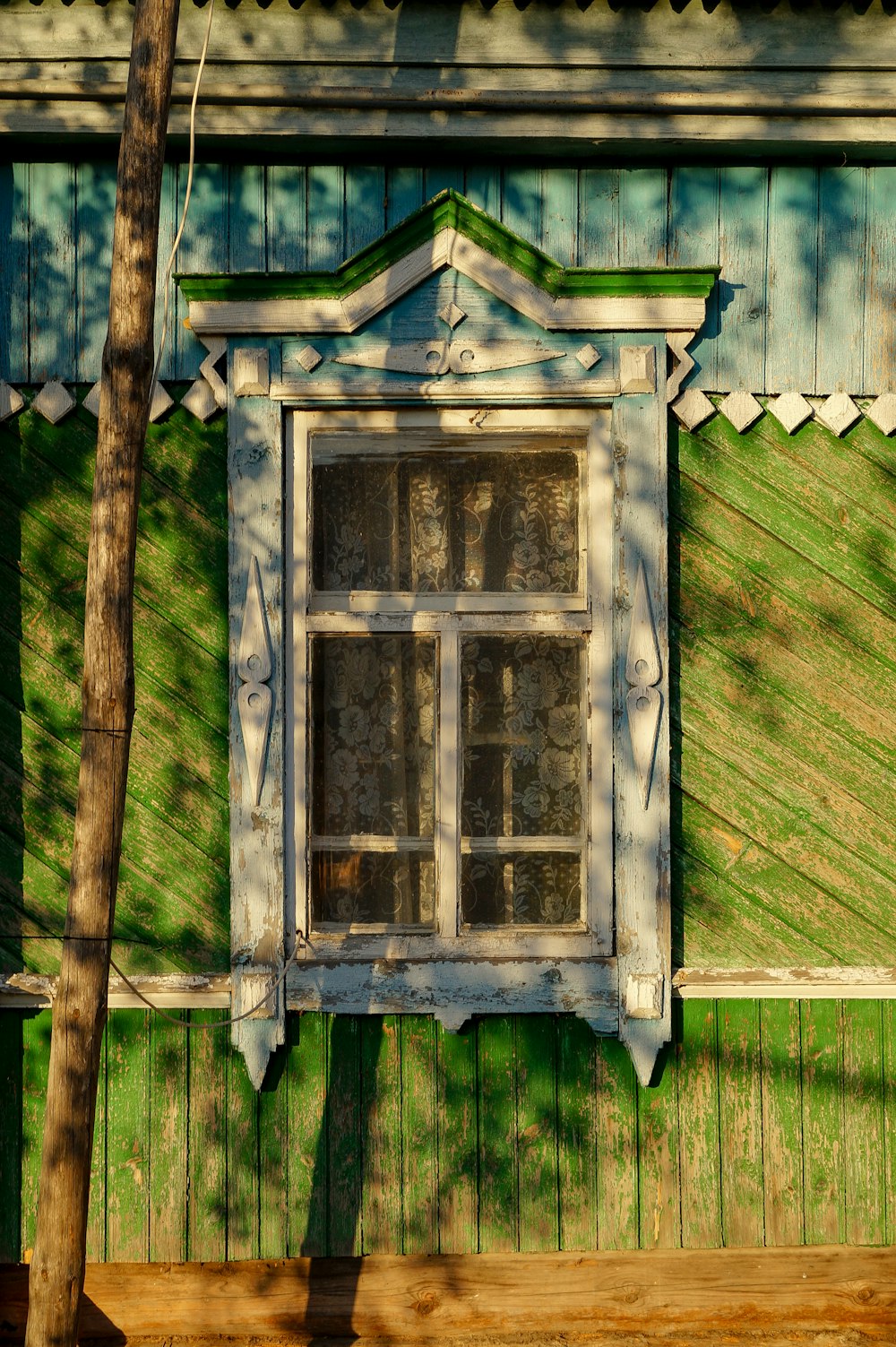 a window on the side of a green building