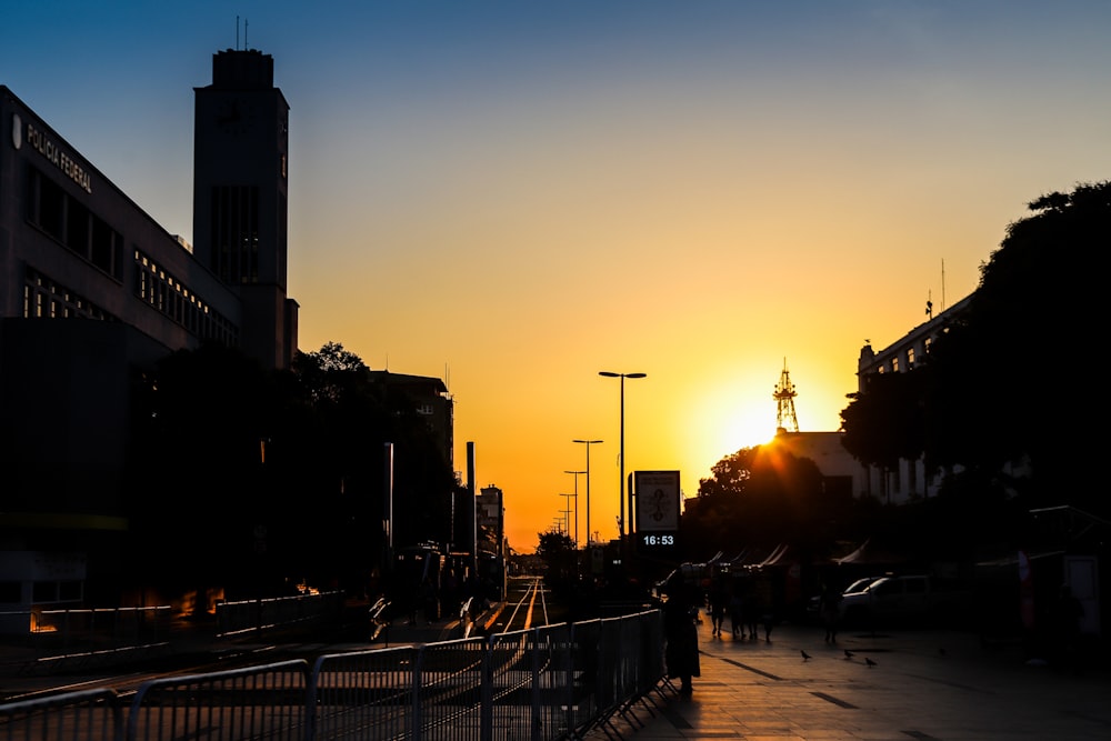 the sun is setting over a city street