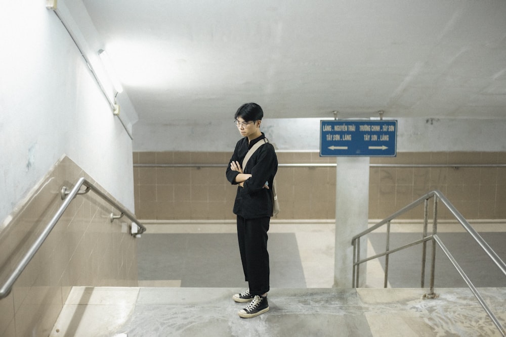 a man standing at the bottom of an escalator