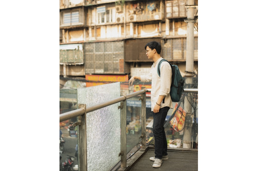 a man with a backpack standing on a balcony