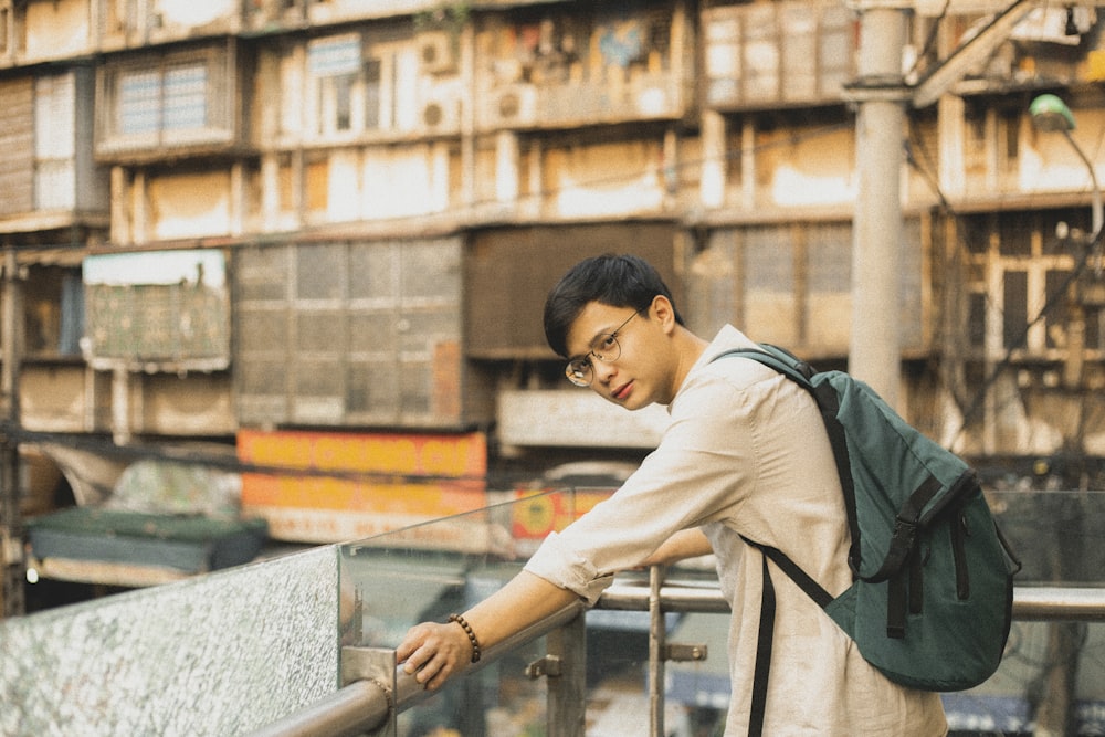 a man with a backpack leaning on a railing