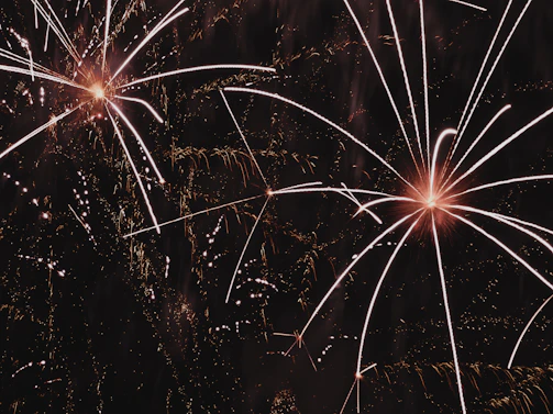 Close-up of sparkling silver fireworks bursting in intricate patterns against a dark sky.