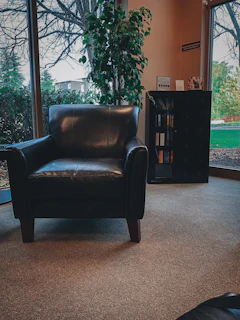 Cozy reading nook in the Orchard Room featuring a plush armchair and a window overlooking the garden.
