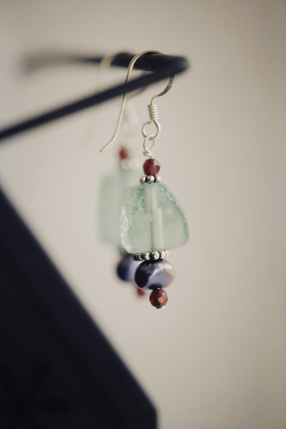 a pair of earrings hanging from a hook