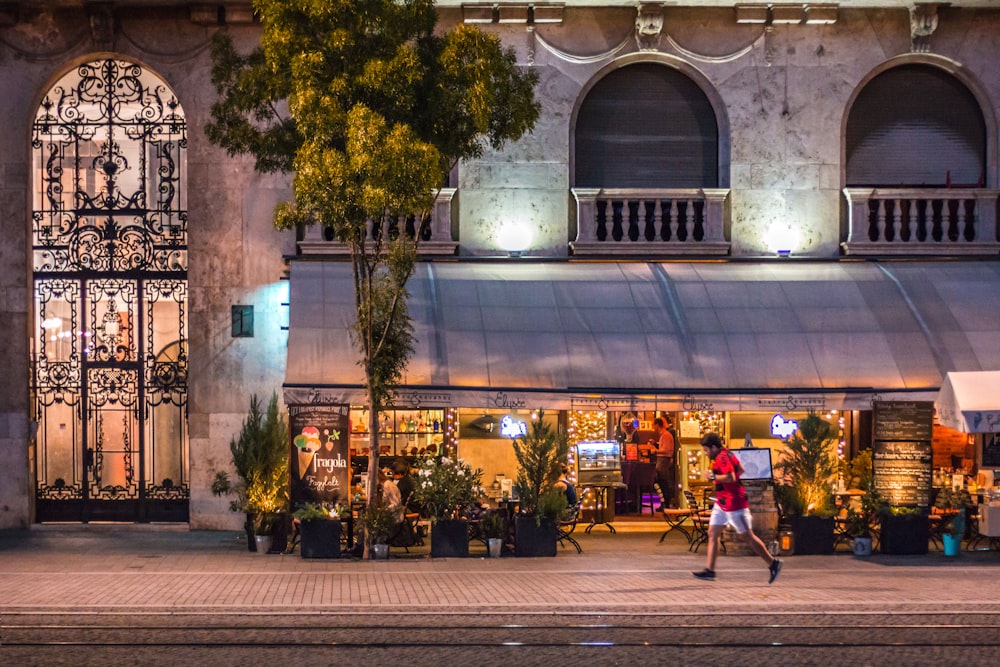 a man walking past a store front at night