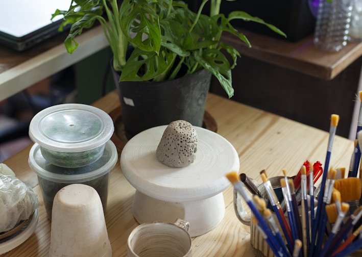 a wooden table topped with lots of craft supplies