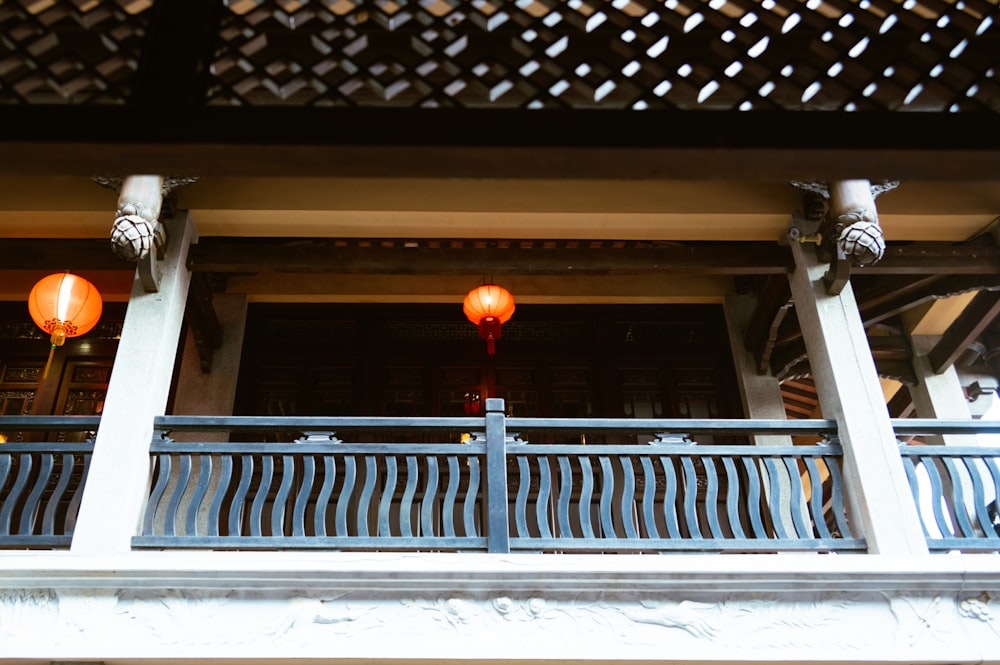 a balcony with two red lanterns hanging from it's sides