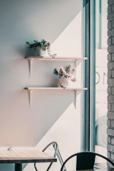 A cozy corner with a small wooden shelf holding seedlings and gardening tools bathed in soft afternoon light.