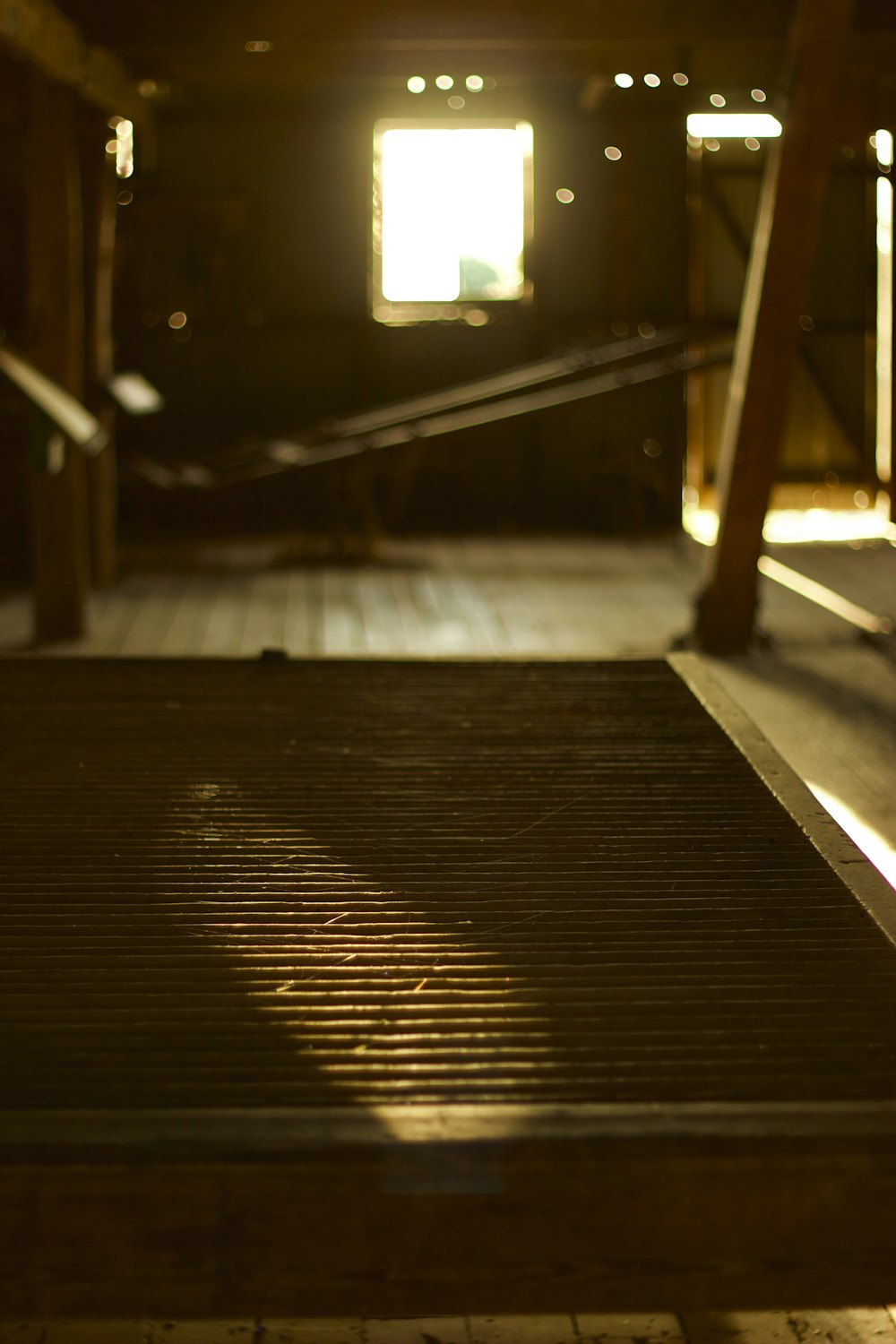 a dark room with a wooden floor and stairs