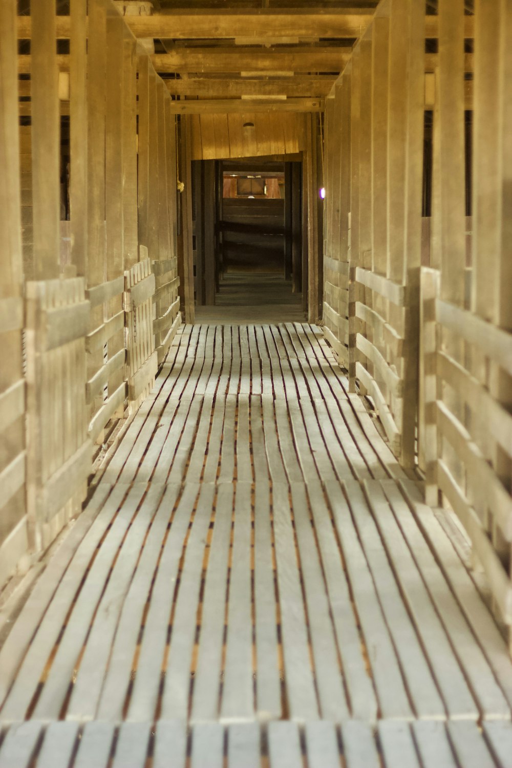 a long hallway with wooden planks and a clock on the wall