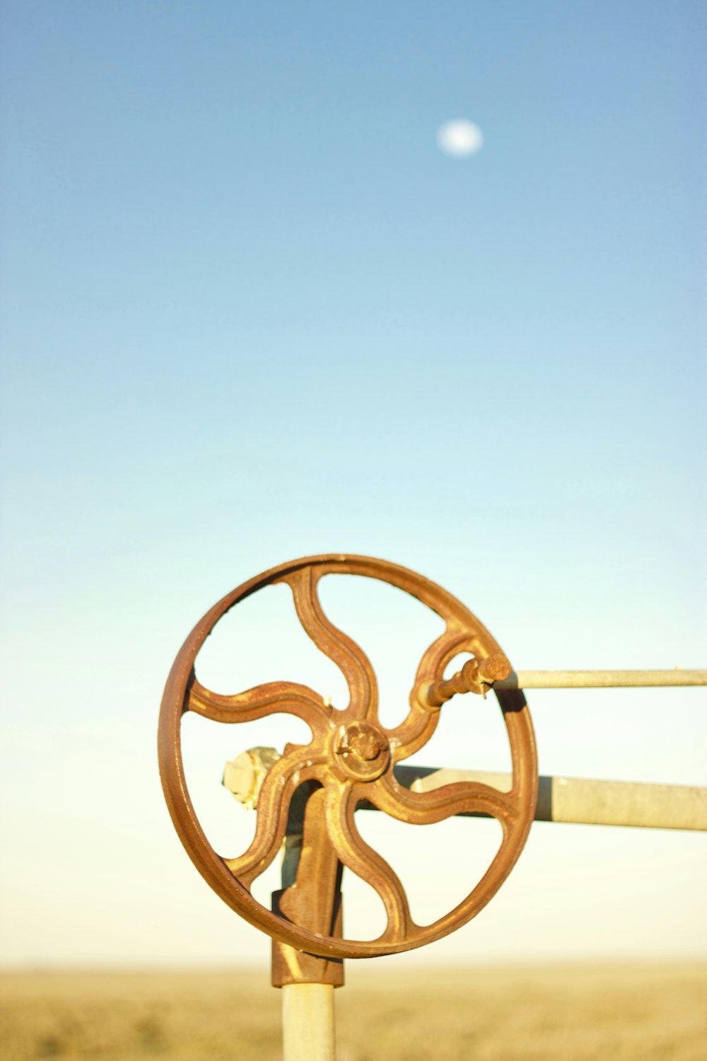 a wooden wheel on a pole in the middle of a field