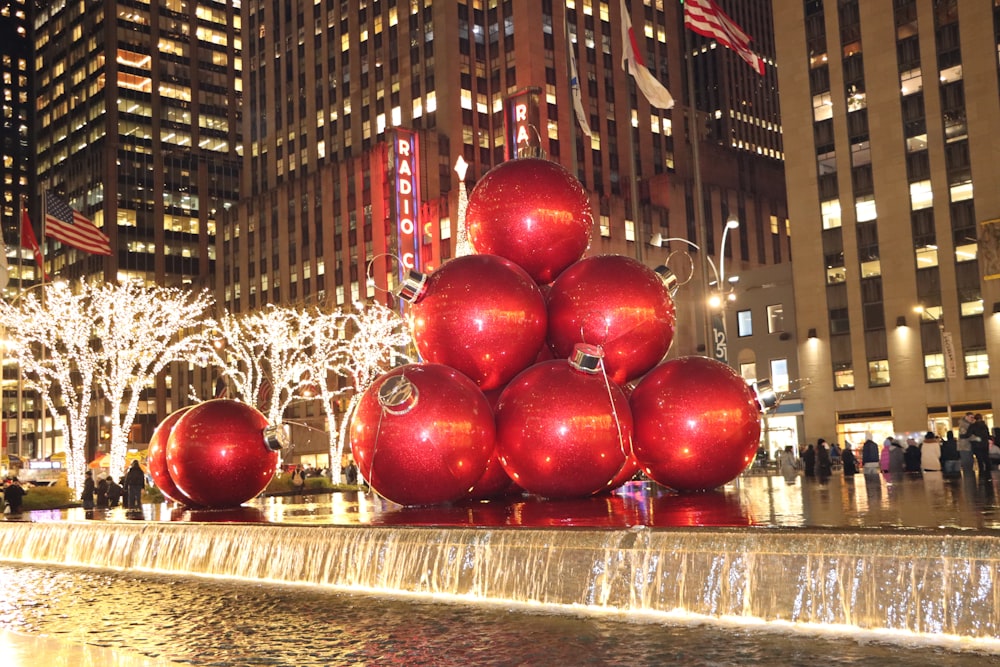 a group of red balls sitting on top of a fountain