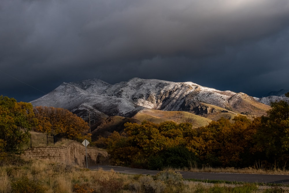 a snow covered mountain range under a cloudy sky