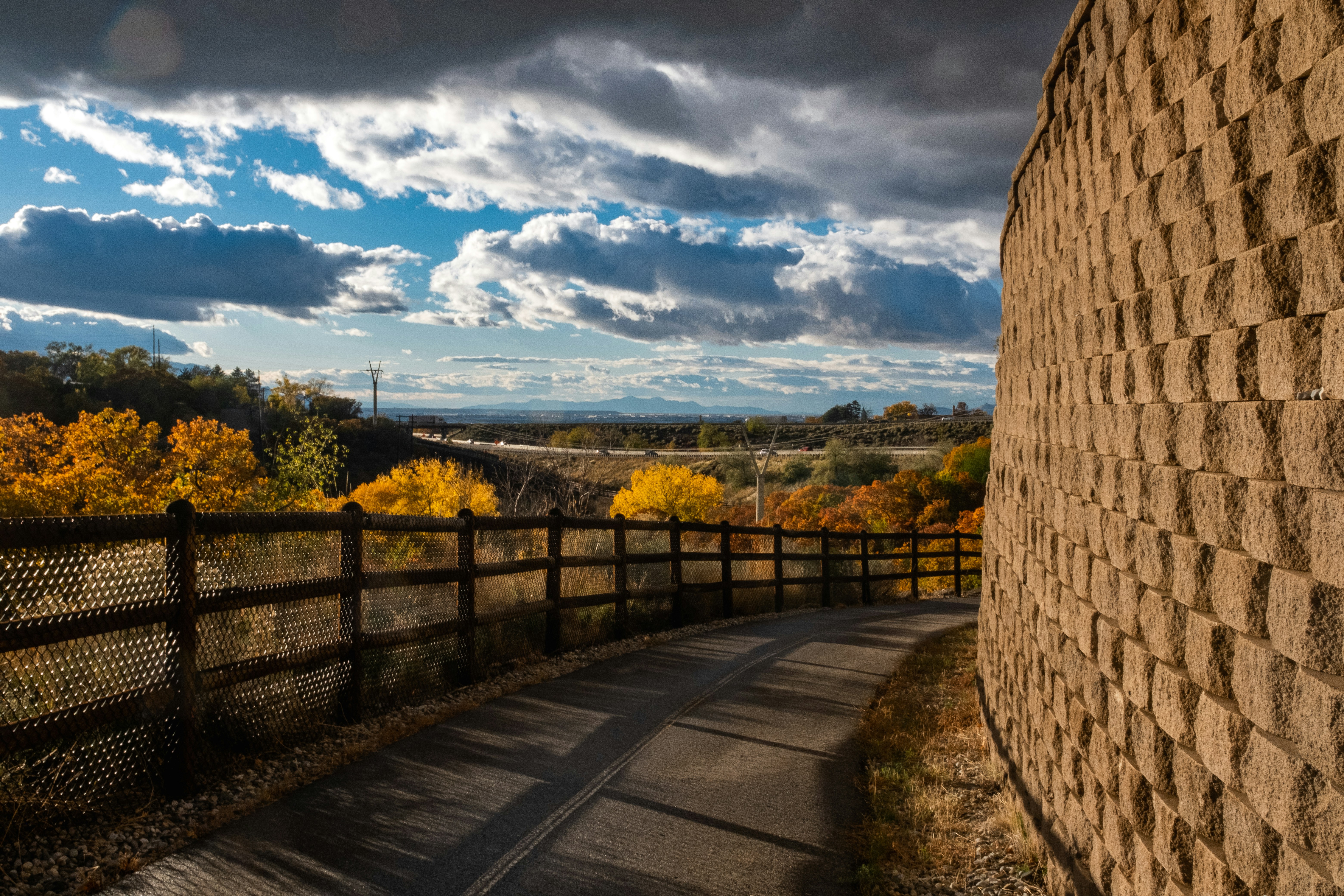 a wooden fence next to a stone wall
