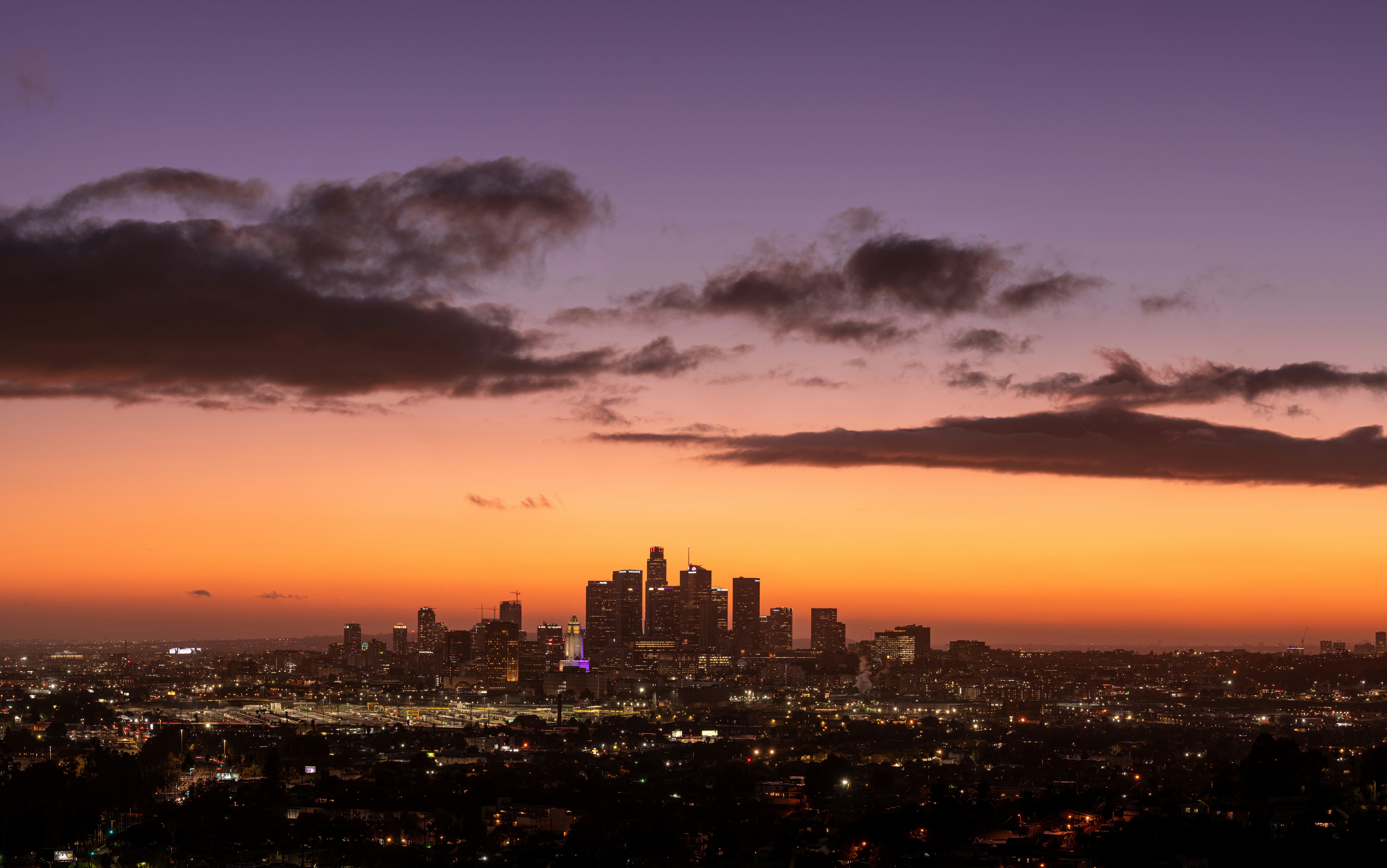 a view of a city at sunset from a hill