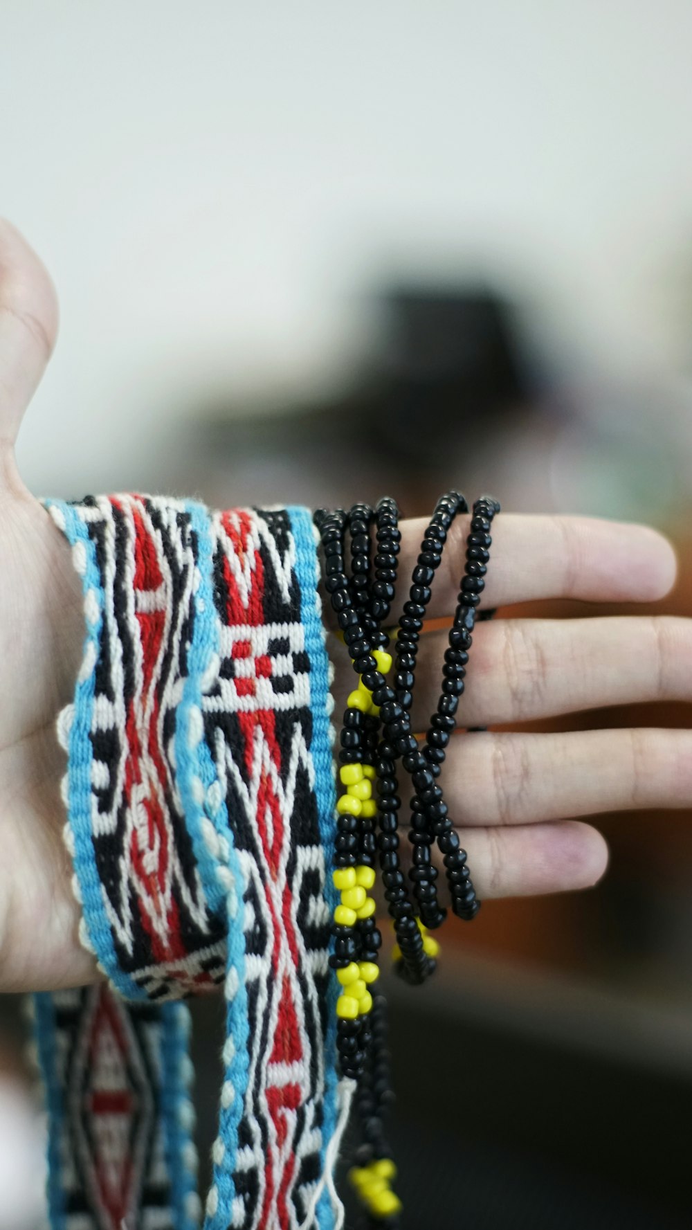 a woman's hand holding several bracelets