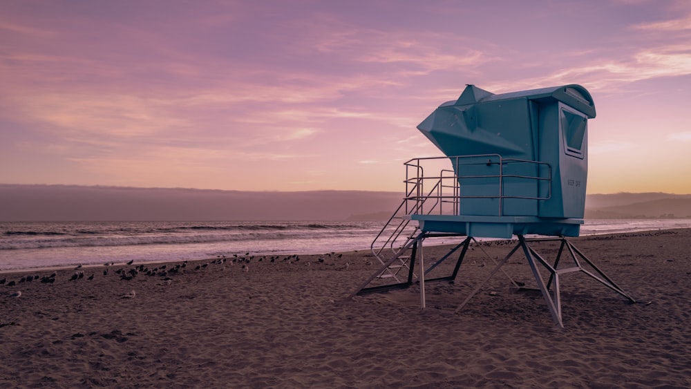 a lifeguard tower on the beach at sunset