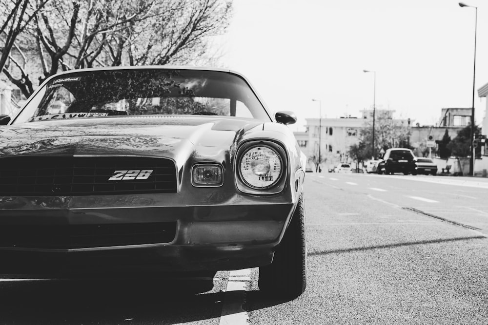 a black and white photo of a car parked on the side of the road