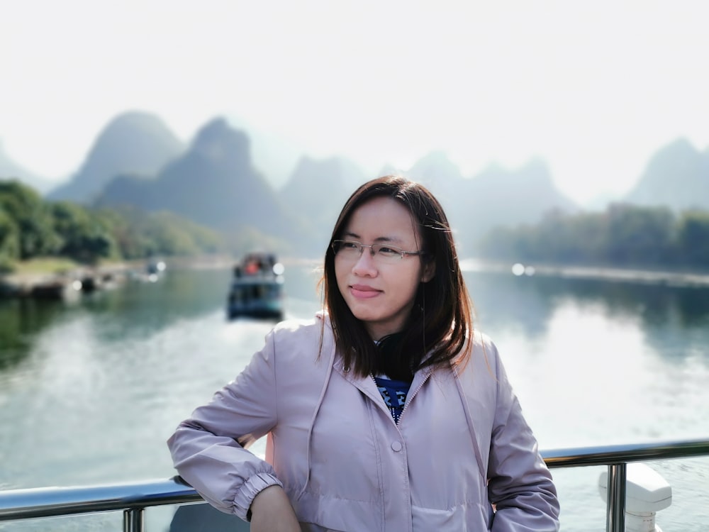 a woman is standing on a boat in the water