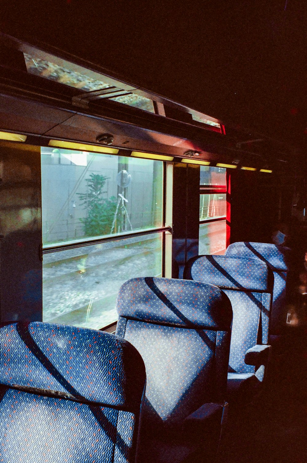 a train car with blue seats and a large screen