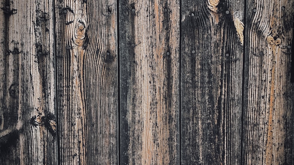 a close up of a wooden wall with peeling paint