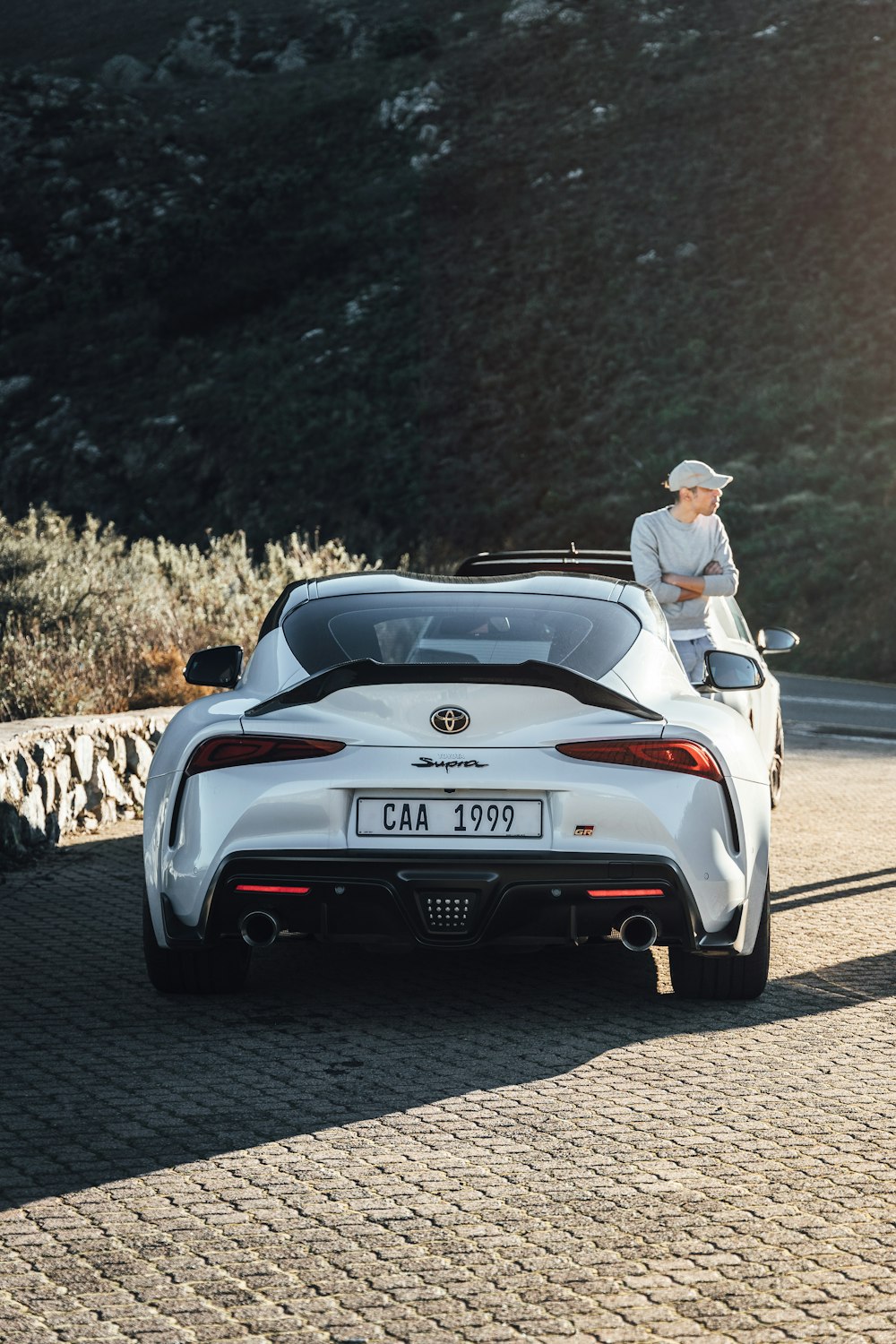 a man sitting on top of a white sports car