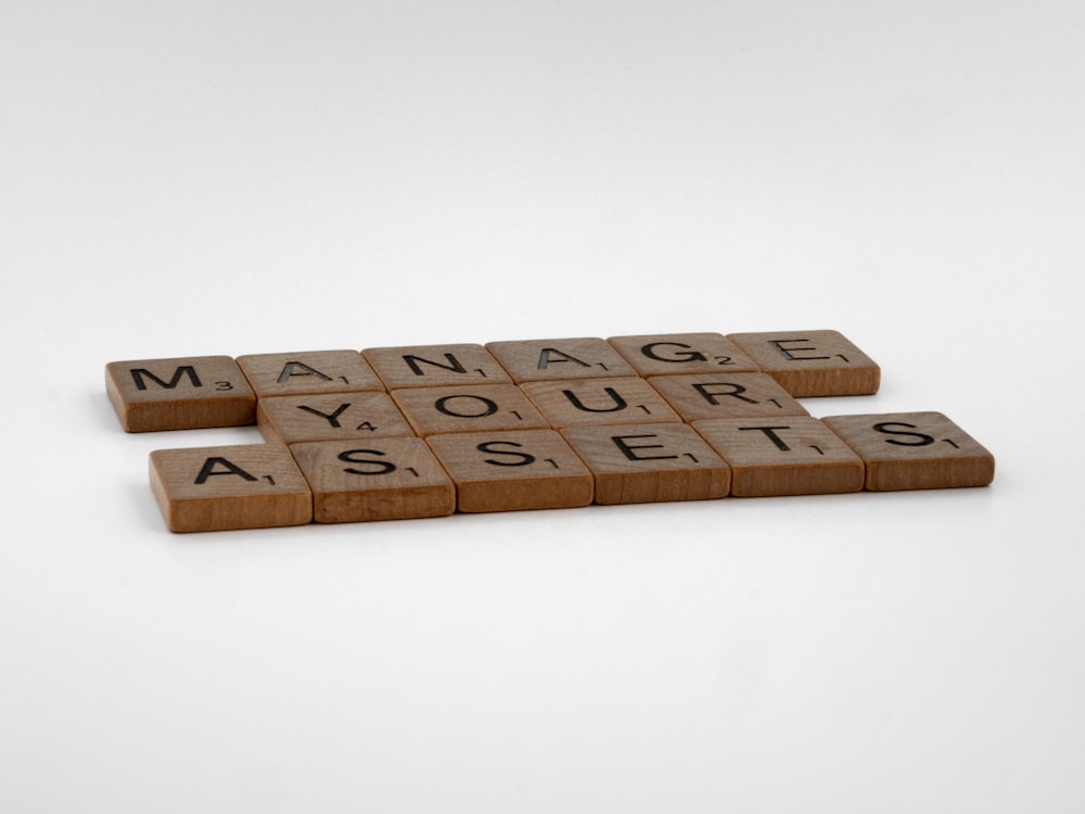 Zwei Scrabble-Kacheln Rechtschreibung Verwalten Sie Ihr Asset