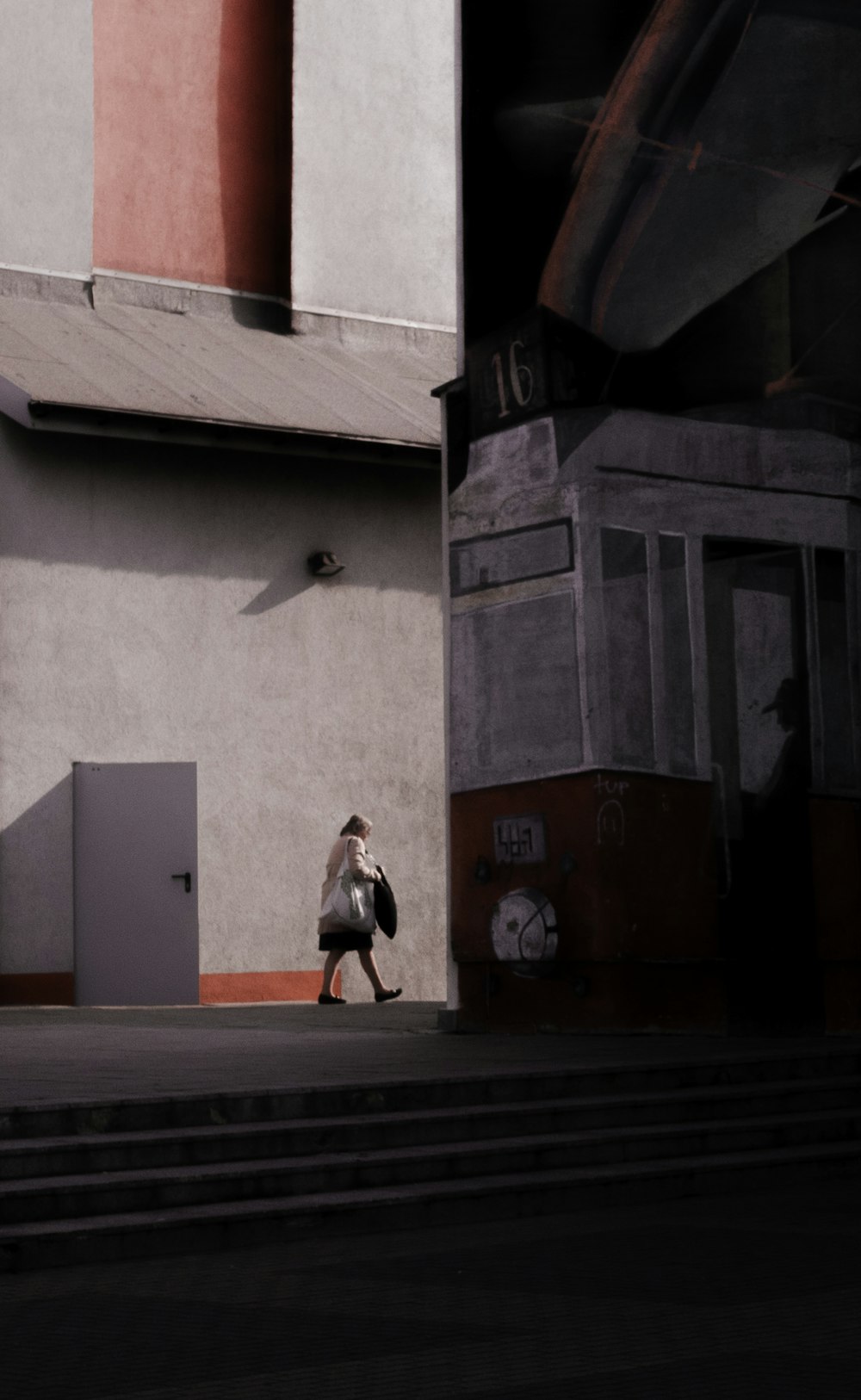 a man walking down a street next to a tall building