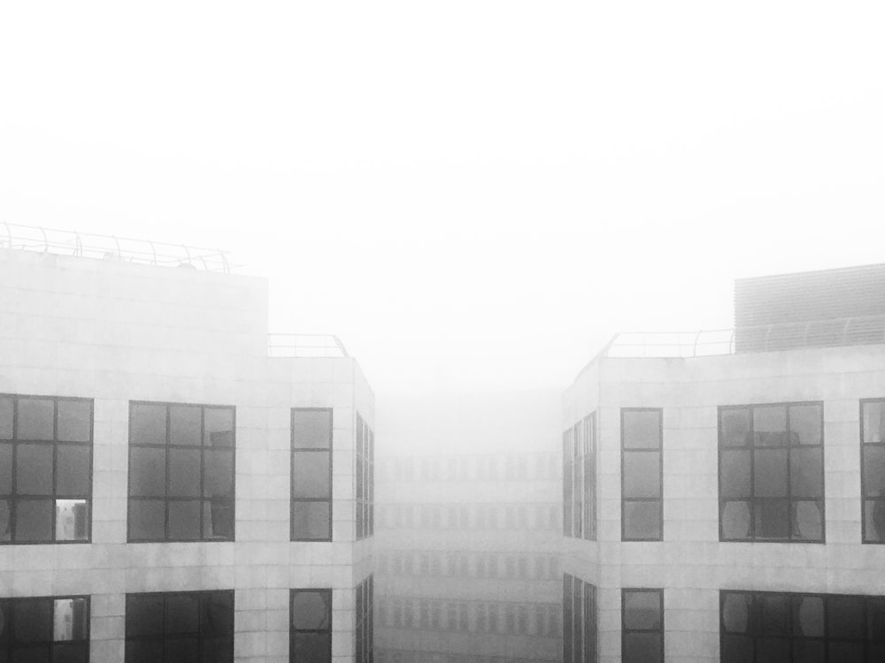 a black and white photo of a building in the fog