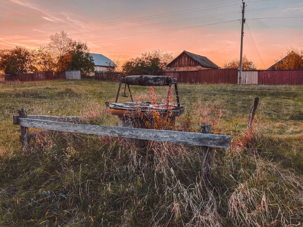 a wooden bench sitting in the middle of a field