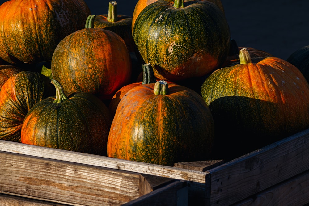 a wooden crate filled with lots of pumpkins