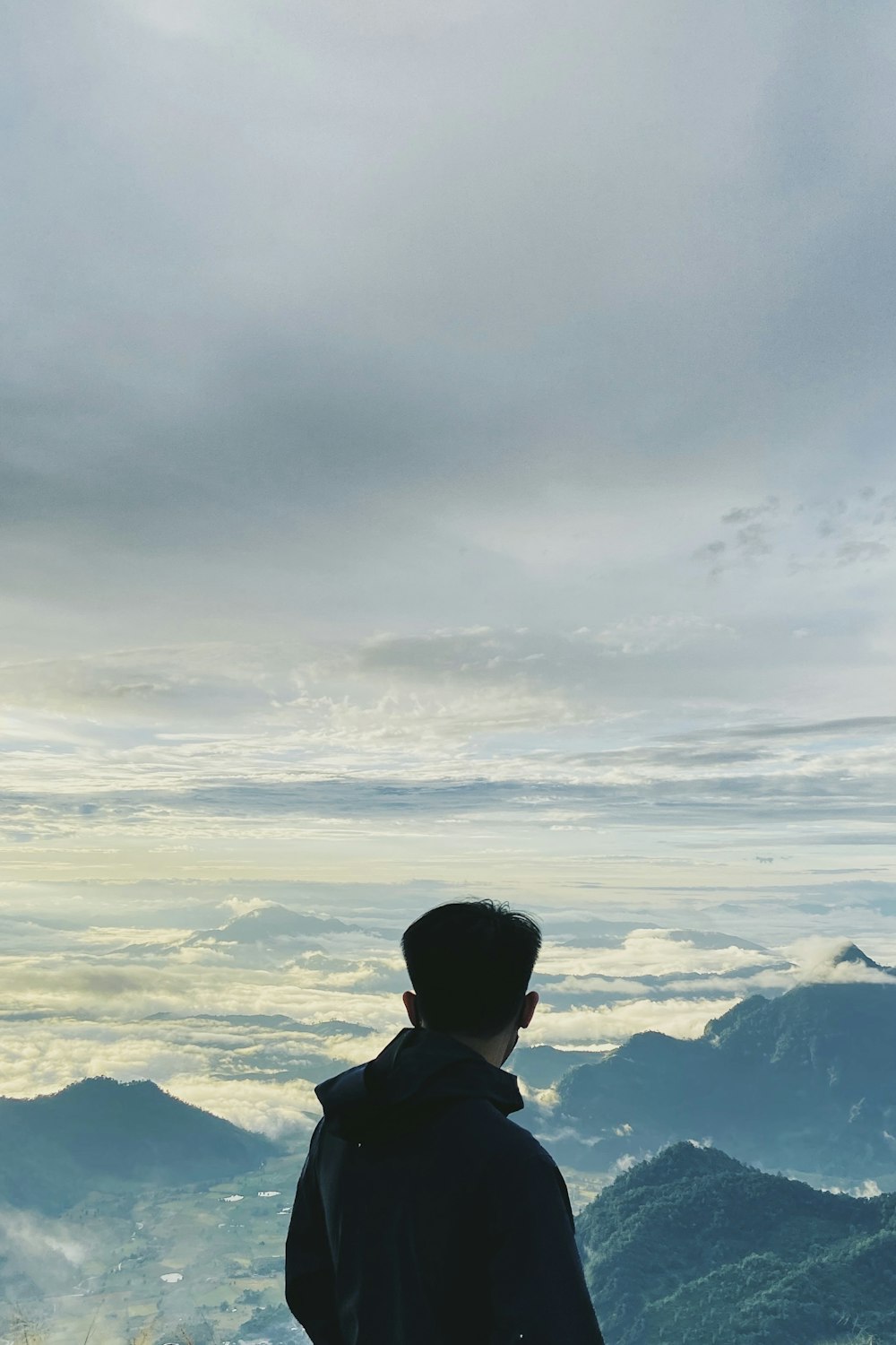 a man standing on top of a mountain looking at the sky