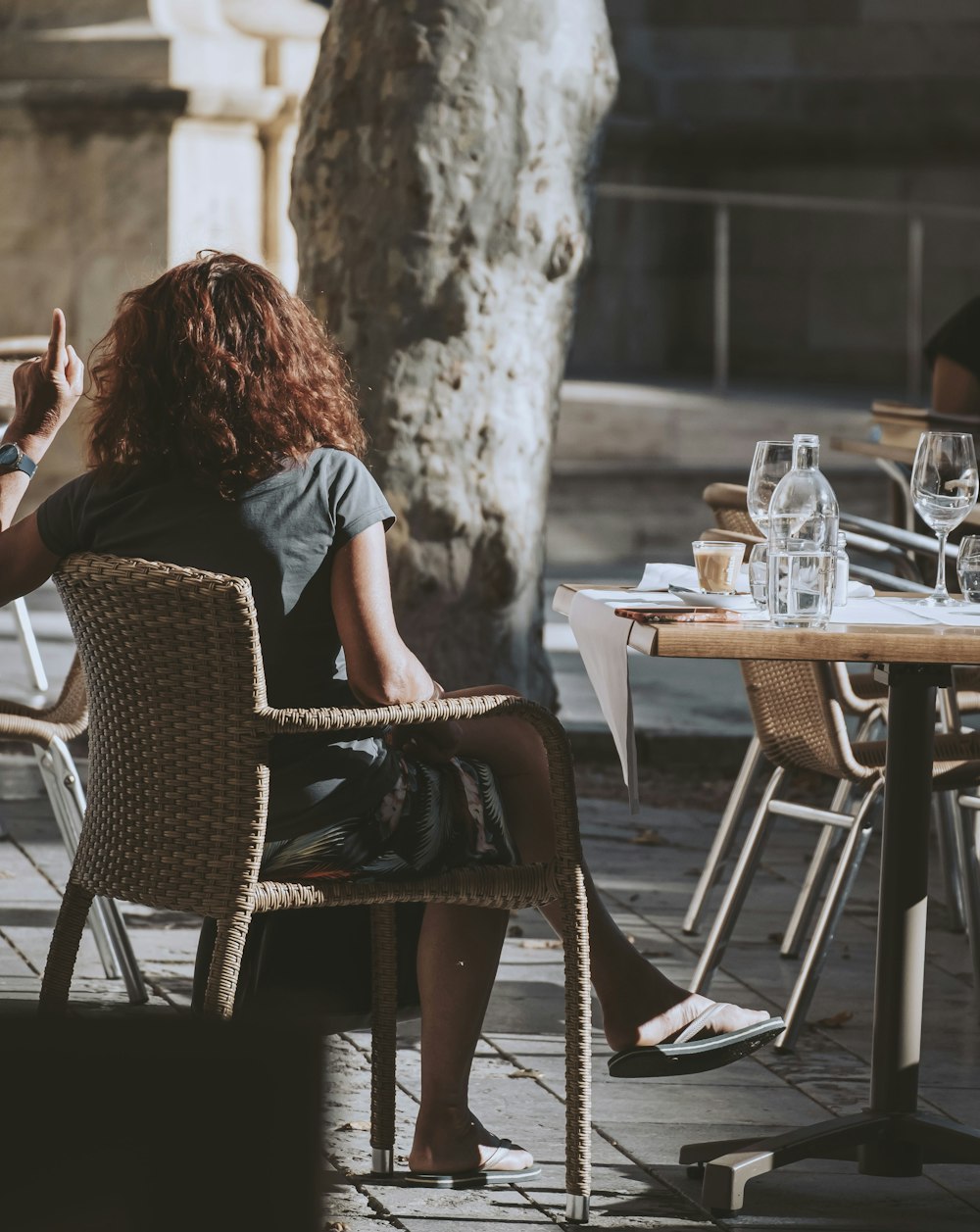 a woman sitting at a table with a glass of wine