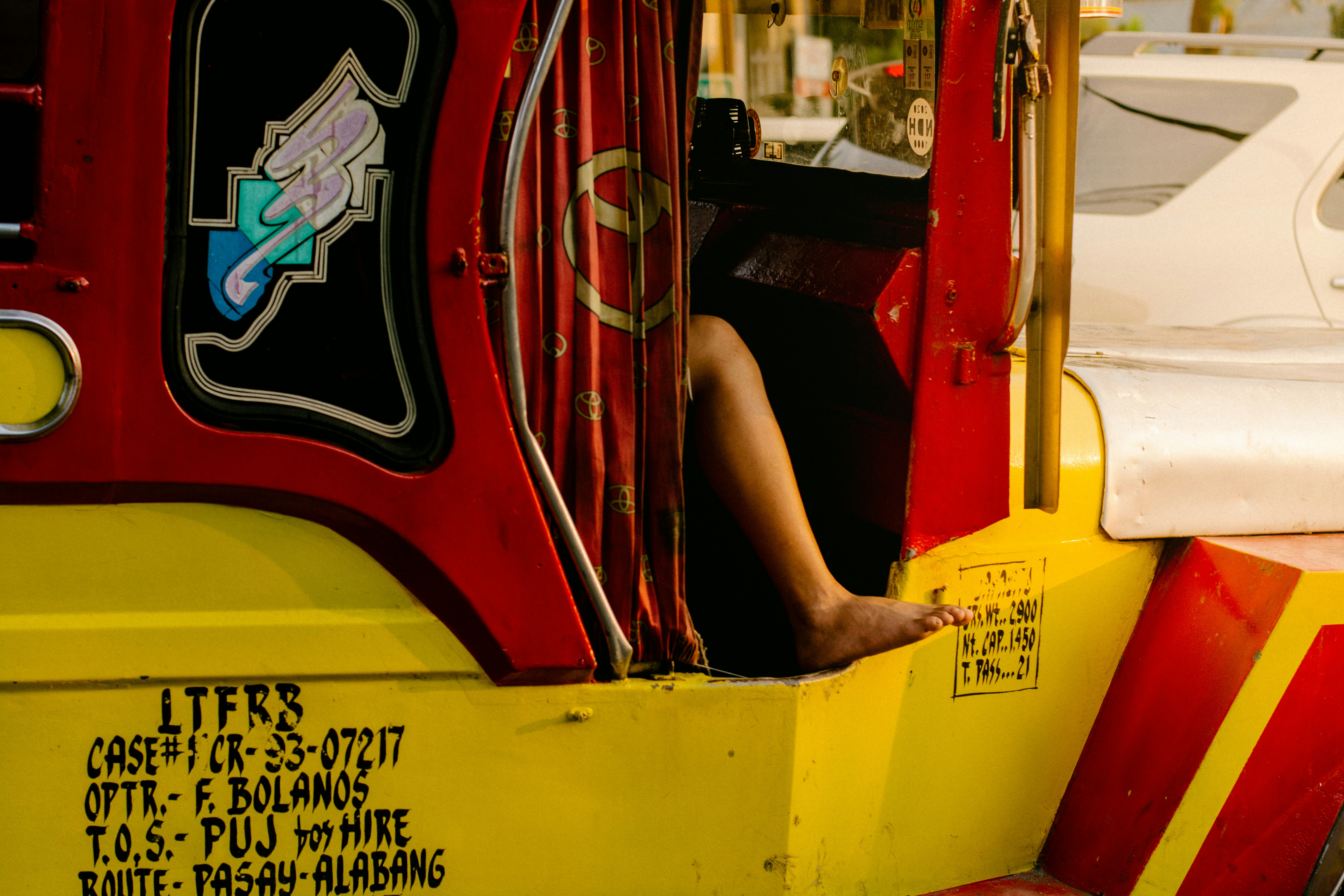a person sitting inside of a red and yellow bus