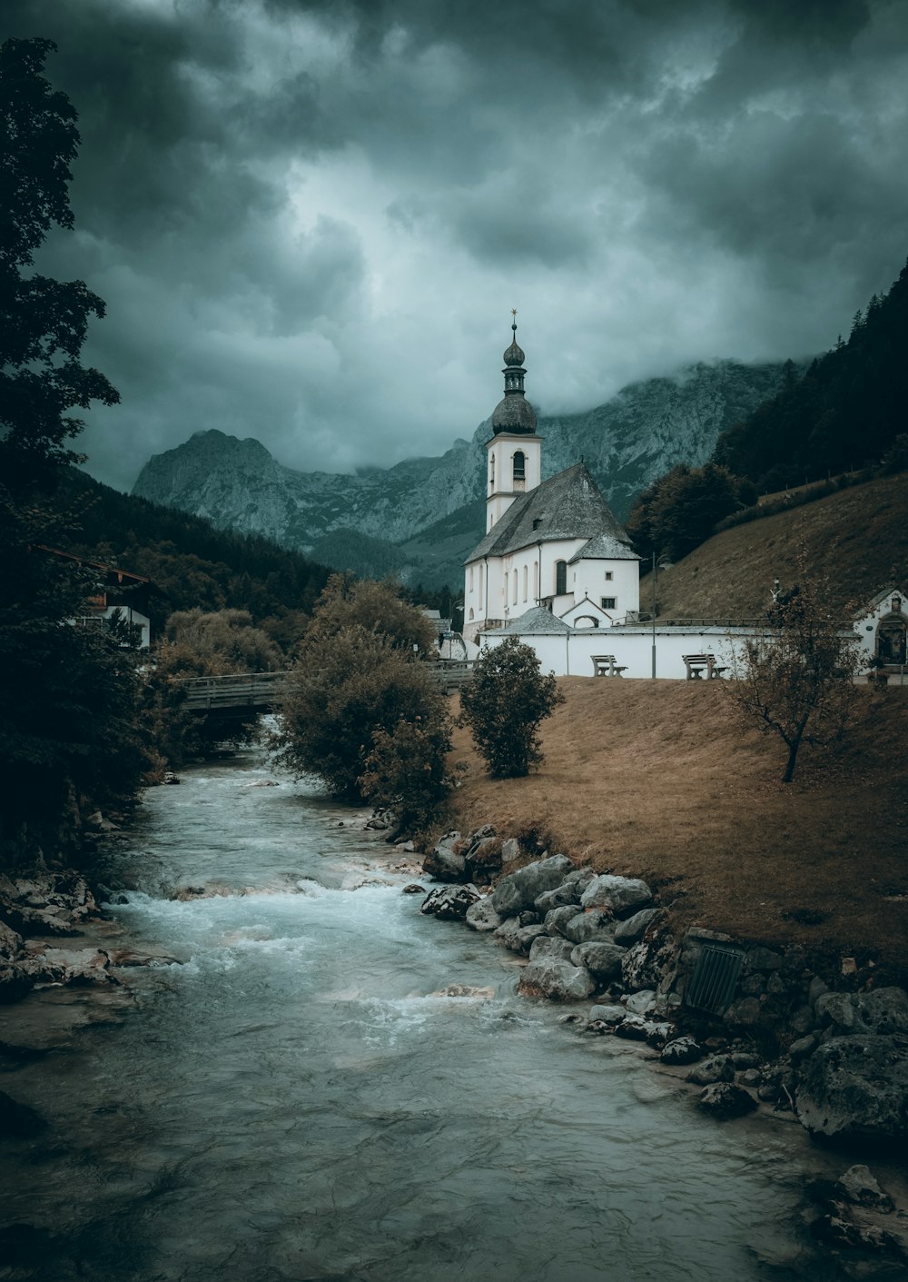 a church on a hill with a river running through it