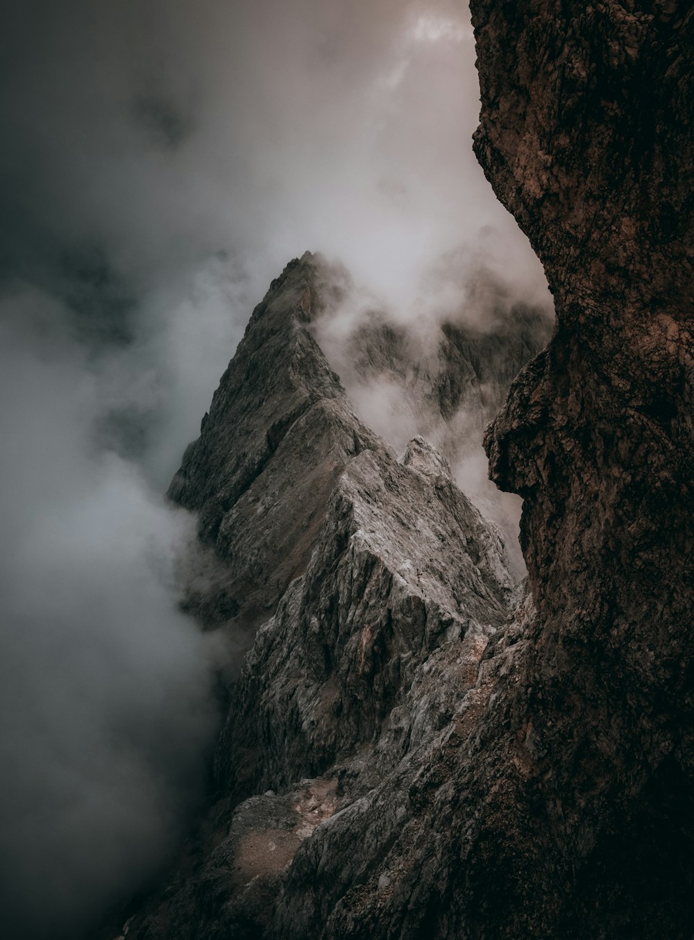 a very tall mountain with some clouds in the sky