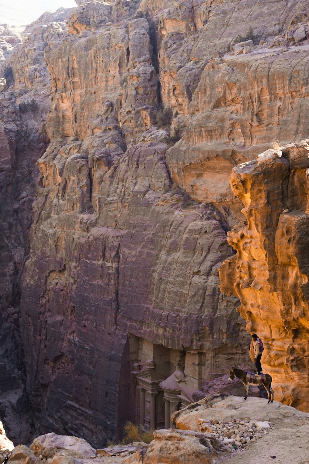 a man standing on top of a mountain next to a cliff