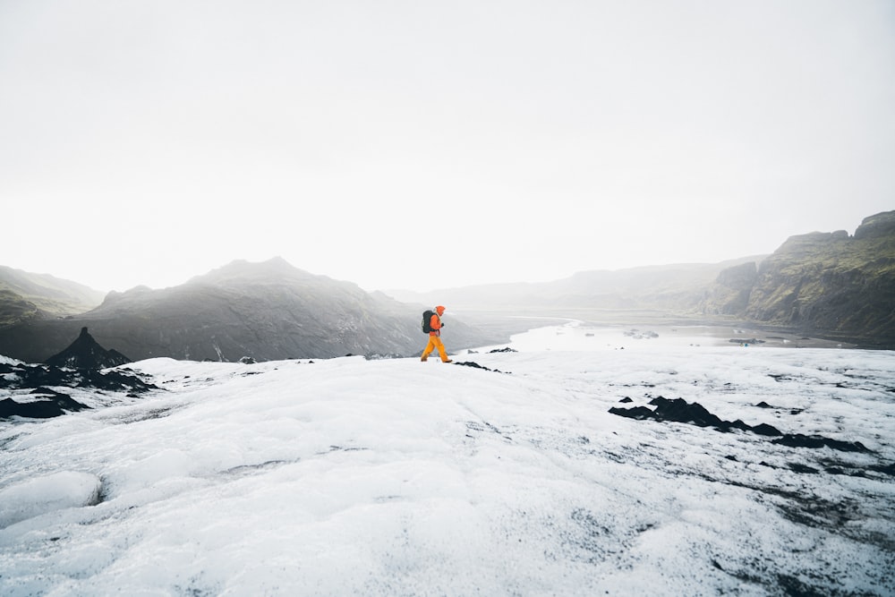 a person standing on top of a snow covered mountain