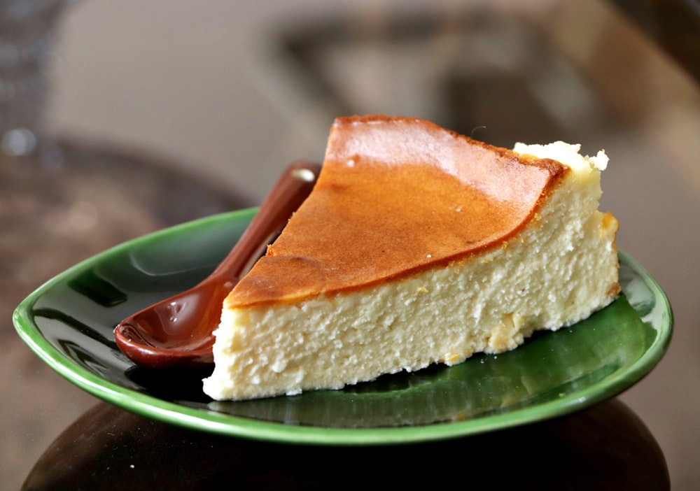 un morceau de gâteau au fromage sur une assiette verte