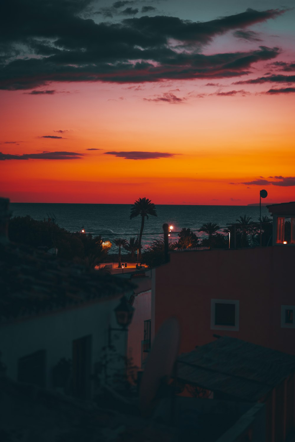 a sunset view of the ocean from a rooftop
