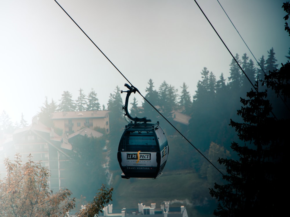 a cable car going up a hill with houses in the background